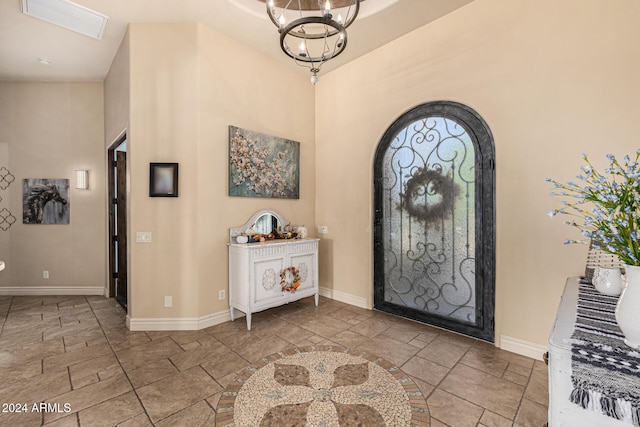 entryway with high vaulted ceiling and a notable chandelier