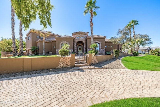 mediterranean / spanish home featuring a front lawn