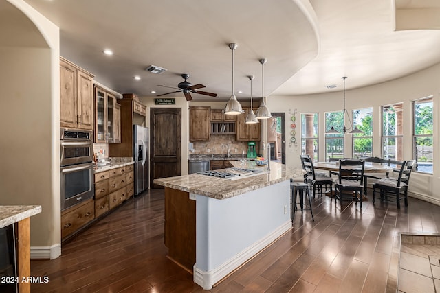 kitchen featuring decorative backsplash, dark hardwood / wood-style flooring, stainless steel appliances, and hanging light fixtures