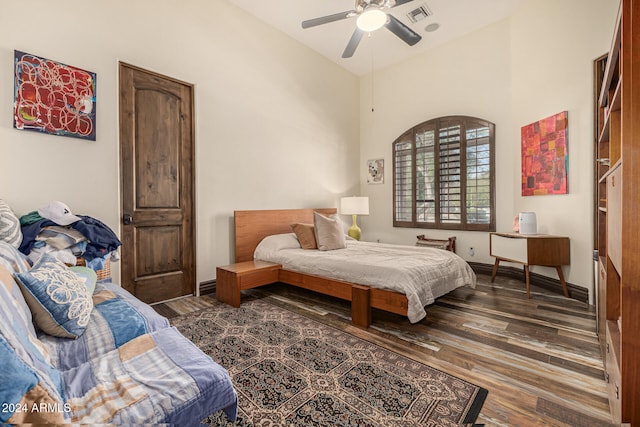 bedroom with dark hardwood / wood-style flooring and ceiling fan