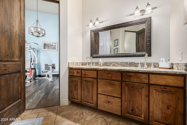 bathroom with hardwood / wood-style floors, vanity, and a chandelier