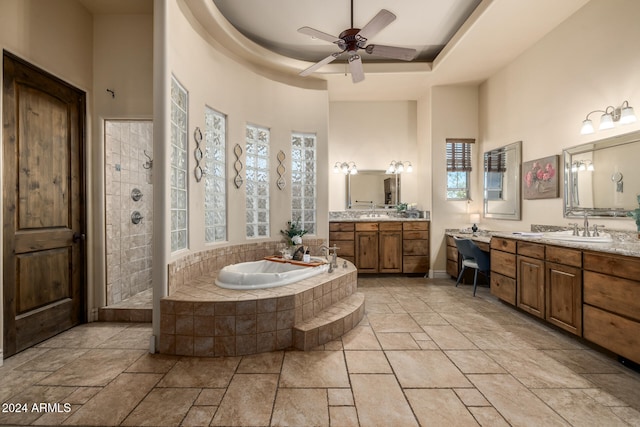 bathroom with a raised ceiling, vanity, plus walk in shower, and a high ceiling