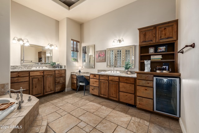 bathroom with vanity, tiled tub, and beverage cooler