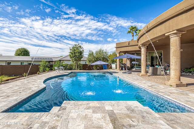 view of swimming pool featuring pool water feature and a patio area