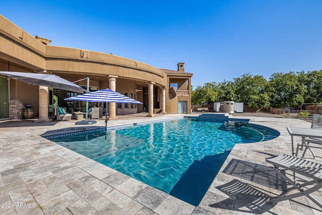 view of swimming pool featuring ceiling fan and a patio