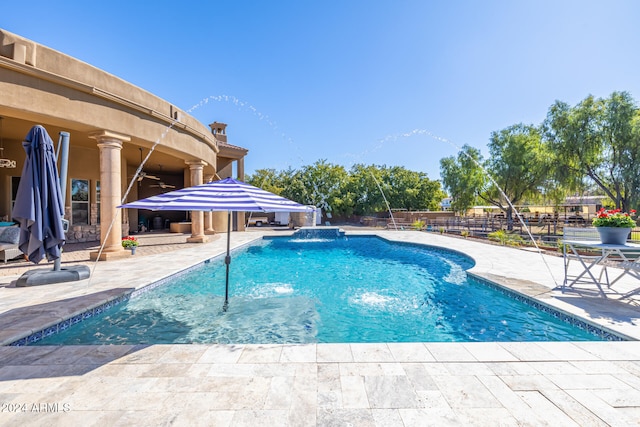 view of swimming pool with pool water feature, a patio, and a hot tub