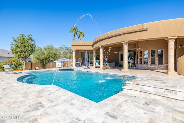 view of pool featuring pool water feature, ceiling fan, and a patio area