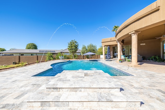 view of swimming pool featuring pool water feature and a patio area