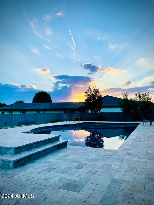 pool at dusk with a patio