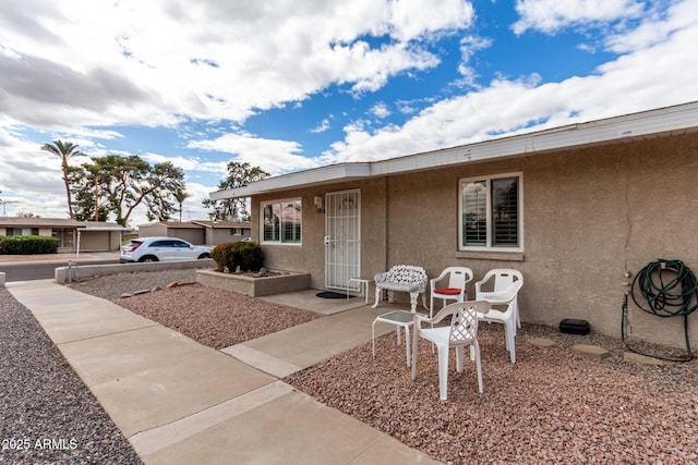 view of front of home with a patio and stucco siding