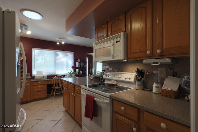 kitchen featuring tasteful backsplash, white appliances, and light tile patterned floors