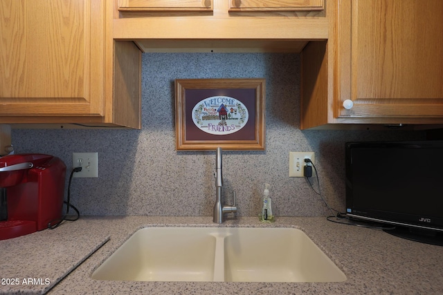 kitchen with sink, backsplash, and light stone counters