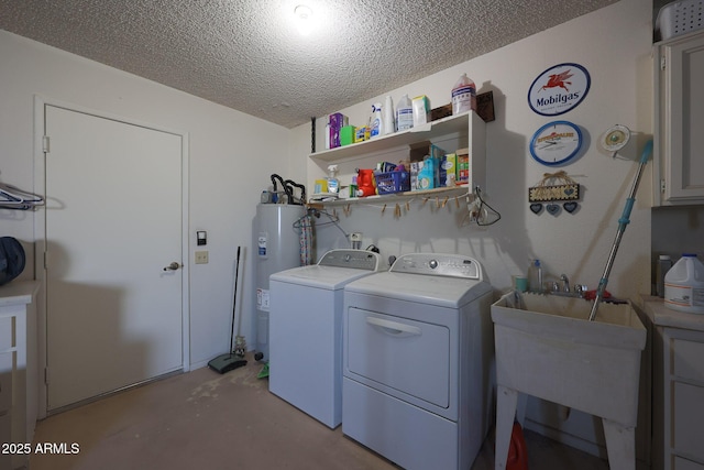 laundry room featuring sink, water heater, cabinets, washing machine and clothes dryer, and a textured ceiling