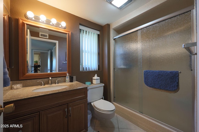 bathroom with vanity, toilet, tile patterned flooring, and a shower with door