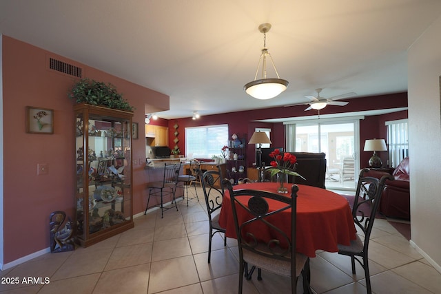 tiled dining space with ceiling fan