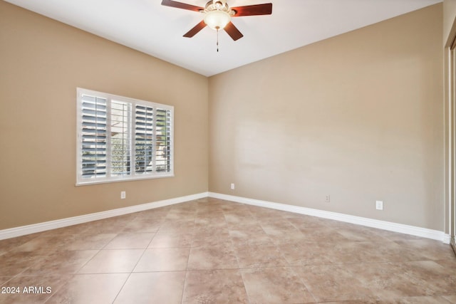 tiled spare room featuring ceiling fan