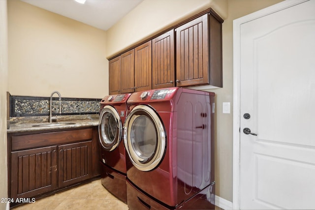 laundry area featuring cabinets, sink, washing machine and clothes dryer, and light tile patterned floors