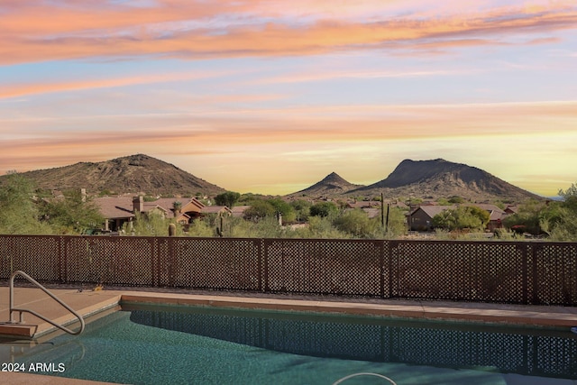 pool at dusk featuring a mountain view