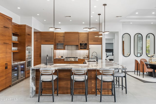 kitchen featuring a large island, a kitchen breakfast bar, appliances with stainless steel finishes, and decorative light fixtures