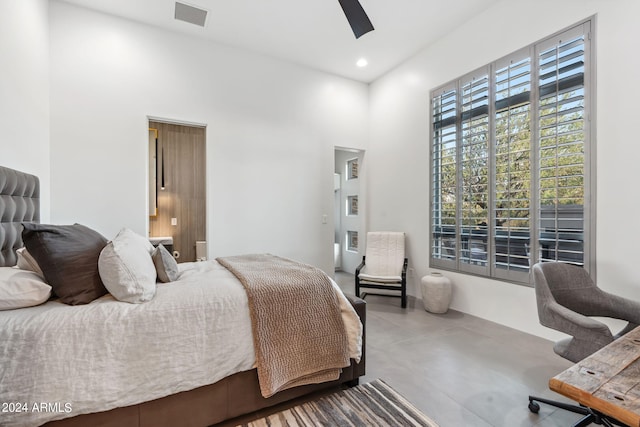 bedroom featuring ceiling fan, a towering ceiling, and concrete flooring