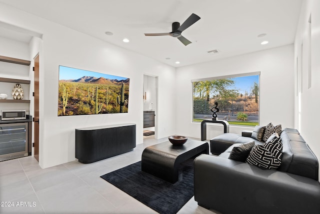 tiled living room with ceiling fan and beverage cooler