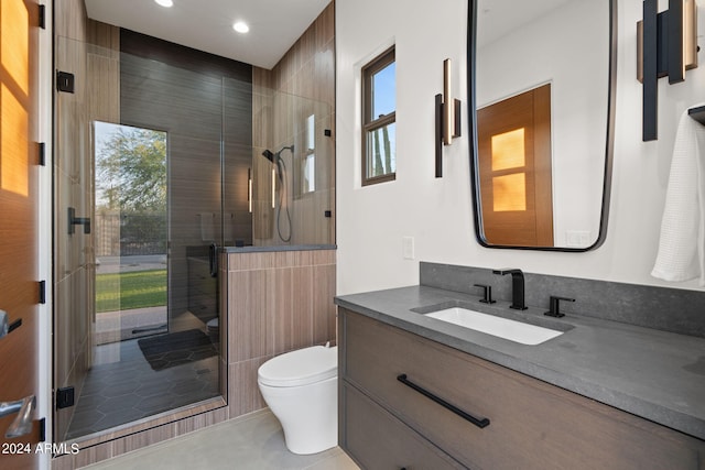 bathroom featuring vanity, a shower with shower door, toilet, and tile patterned floors