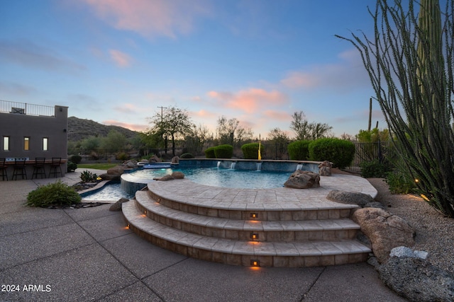 pool at dusk featuring a patio