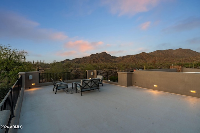 patio terrace at dusk featuring a mountain view