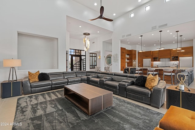 tiled living room featuring a high ceiling, sink, and ceiling fan