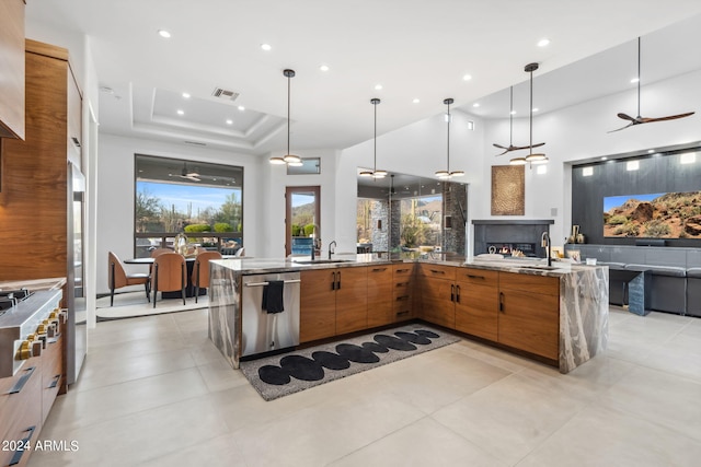 kitchen with dishwasher, sink, hanging light fixtures, a raised ceiling, and ceiling fan