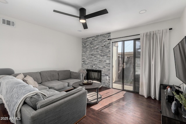 living room with dark hardwood / wood-style flooring, a fireplace, and ceiling fan