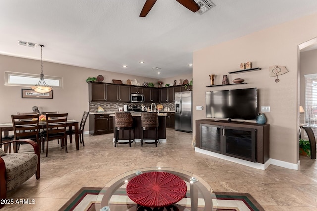 living room featuring a healthy amount of sunlight and ceiling fan