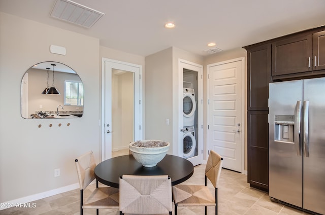 dining room with light tile patterned floors and stacked washer and clothes dryer