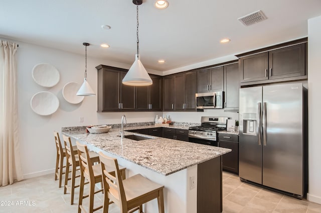 kitchen with sink, a breakfast bar area, hanging light fixtures, stainless steel appliances, and kitchen peninsula