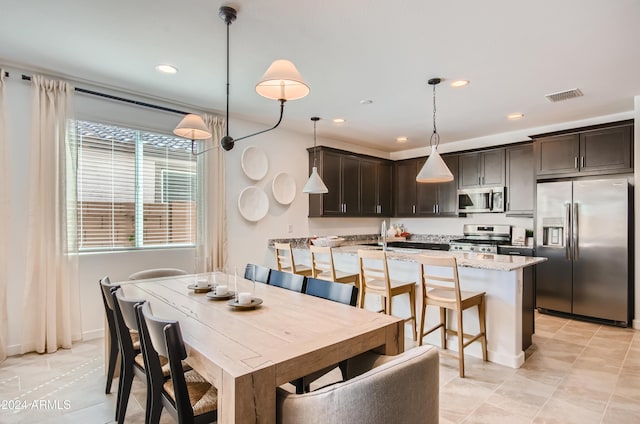 dining area featuring sink and light tile patterned floors