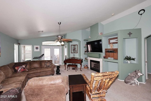 living room with lofted ceiling, ceiling fan, french doors, and carpet