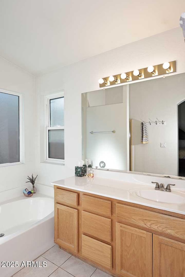 bathroom featuring tile patterned flooring, a bath, and vanity