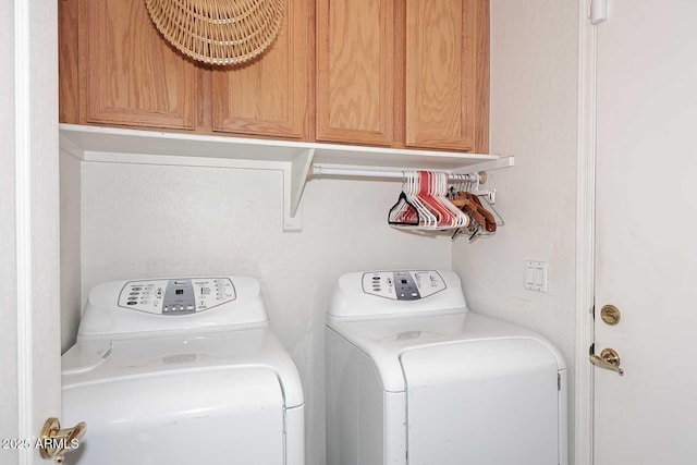 washroom featuring cabinets and washing machine and clothes dryer