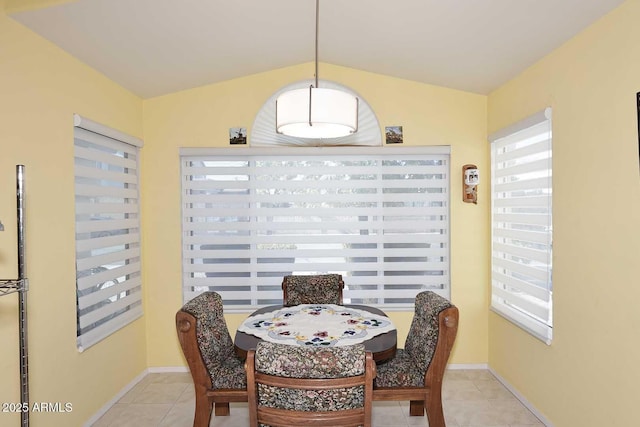 dining area with vaulted ceiling and light tile patterned flooring