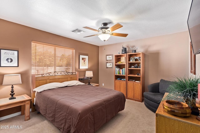 carpeted bedroom with a textured ceiling and ceiling fan