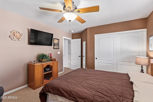 carpeted bedroom featuring ceiling fan and a closet