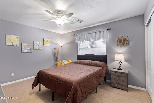 bedroom with light carpet, a textured ceiling, a closet, and ceiling fan