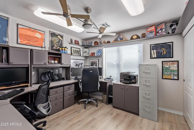 office area with a textured ceiling, ceiling fan, and light wood-type flooring