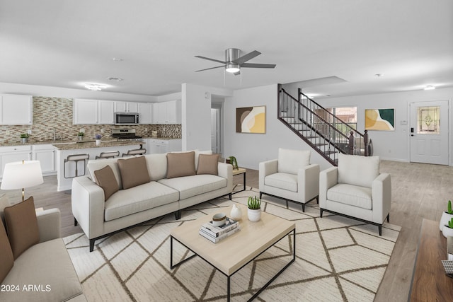 living room featuring ceiling fan and light hardwood / wood-style floors