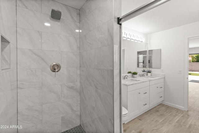 bathroom featuring toilet, vanity, and tiled shower