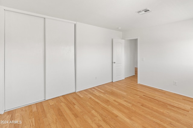 unfurnished bedroom featuring a closet and light hardwood / wood-style floors