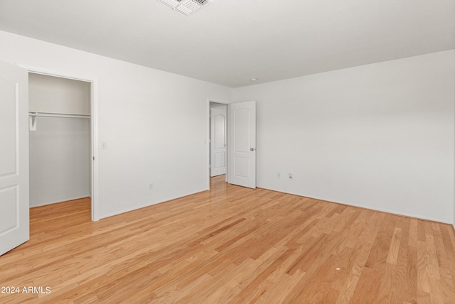 unfurnished bedroom featuring light hardwood / wood-style flooring and a closet