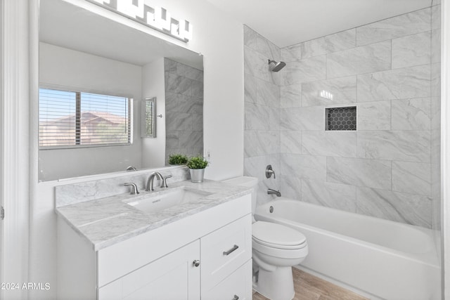 full bathroom with tiled shower / bath combo, toilet, wood-type flooring, and vanity