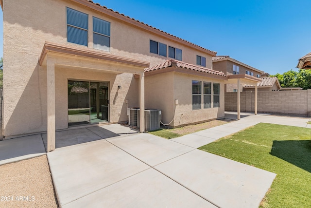 back of property featuring central air condition unit, a patio area, and a yard