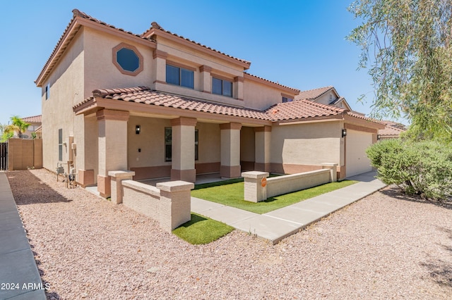 mediterranean / spanish-style home with a garage and a patio